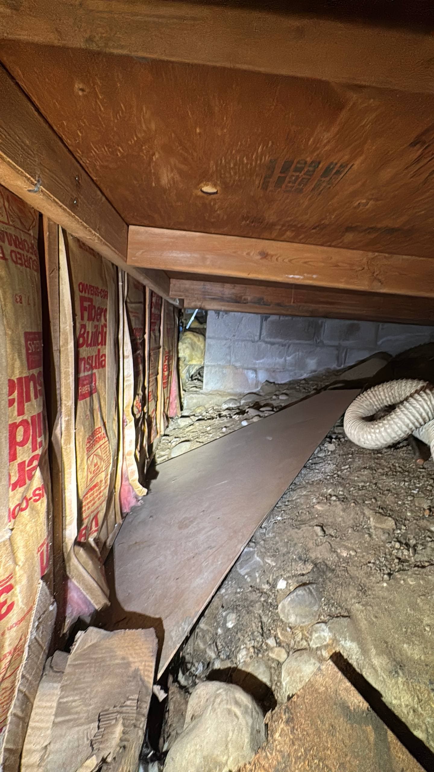 New crawl space insulation installed beneath floor joists